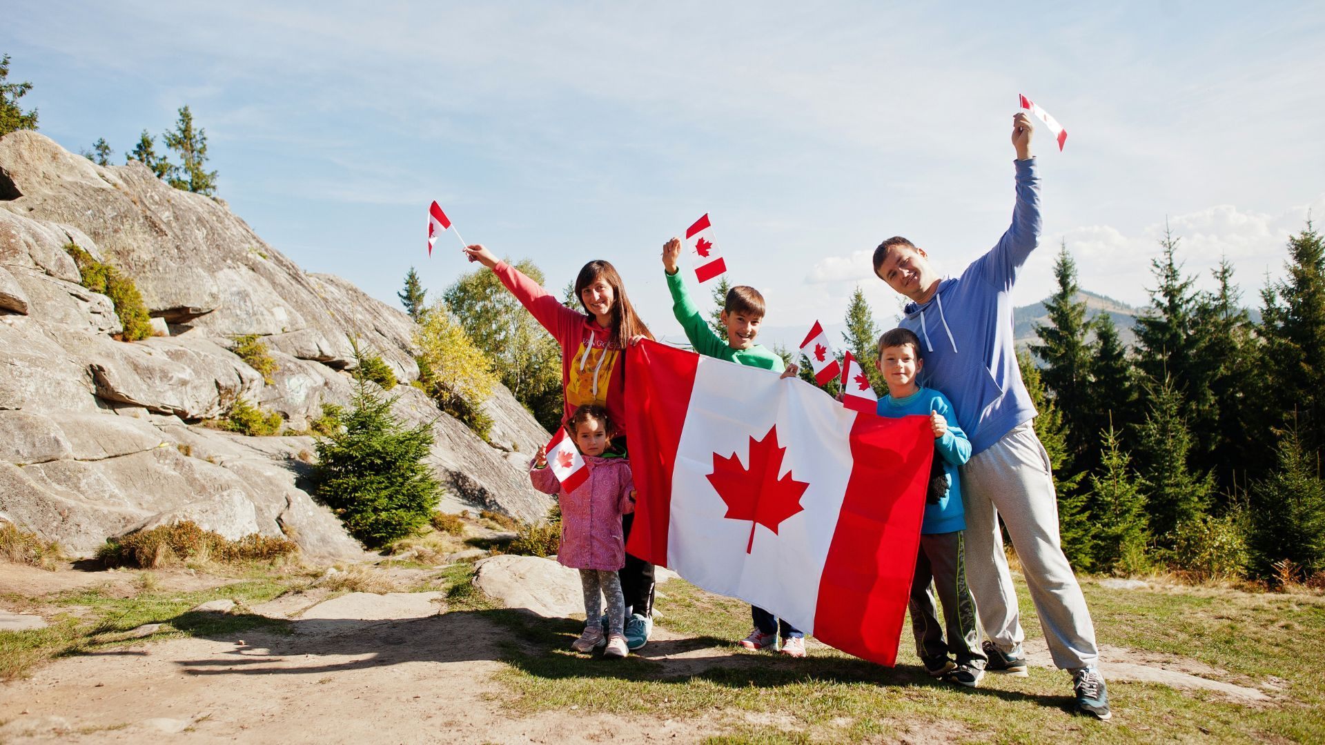 Family celebrating Canadian permanent residence with flags